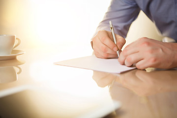 Image showing The male hands with a pen and the cup