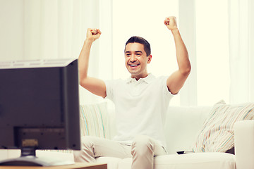 Image showing smiling man watching sports at home