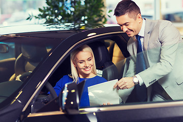 Image showing happy woman with car dealer in auto show or salon