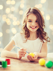 Image showing close up of girl with brush coloring easter eggs