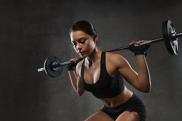 Image showing young woman flexing muscles with barbell in gym