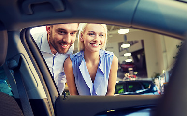 Image showing happy couple buying car in auto show or salon