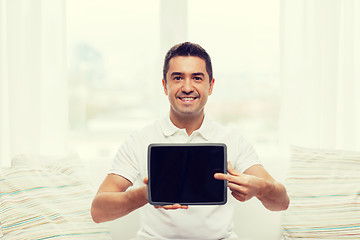 Image showing smiling man showing tablet pc blank screen at home