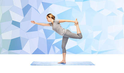 Image showing woman making yoga in lord of the dance pose on mat