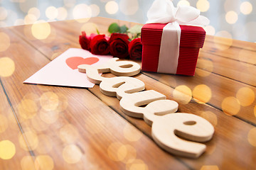 Image showing close up of gift box, red roses and greeting card