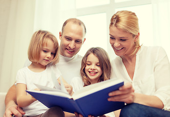 Image showing smiling family and two little girls with book