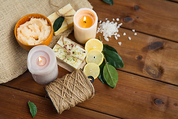 Image showing close up of natural soap and candles on wood