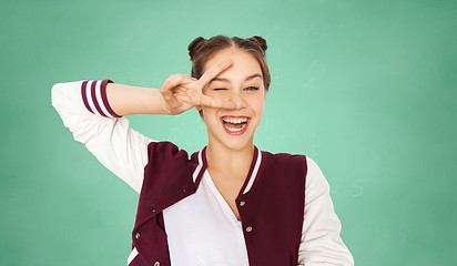 Image showing happy teenage student girl showing peace sign