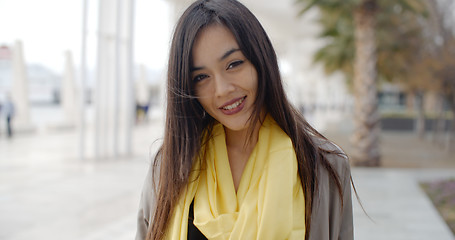 Image showing Joyful grinning woman outside in yellow scarf