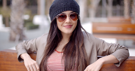 Image showing Happy relaxed trendy woman sitting daydreaming