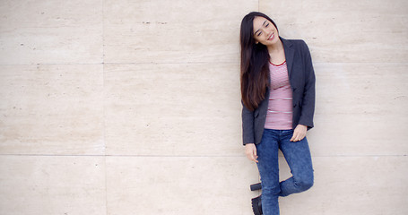 Image showing Trendy young woman posing against a wall