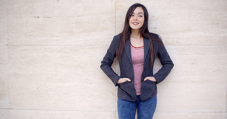 Image showing Trendy young woman posing against a wall