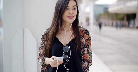 Image showing Smiling young woman walking through town