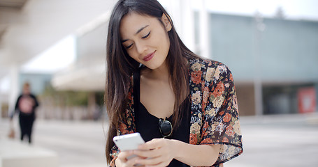 Image showing Young woman sitting reading a text message