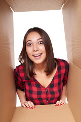 Image showing Girl opening a carton box and looking inside