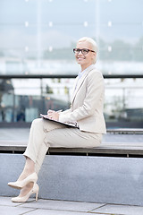 Image showing young smiling businesswoman with notepad outdoors