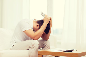 Image showing man with money and calculator at home