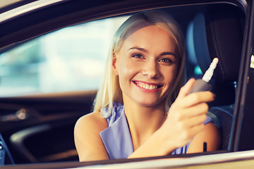 Image showing happy woman getting car key in auto show or salon