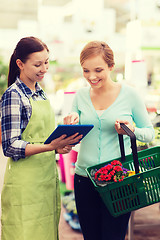 Image showing happy women with tablet pc in greenhouse