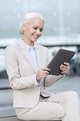 Image showing smiling businesswoman with tablet pc outdoors