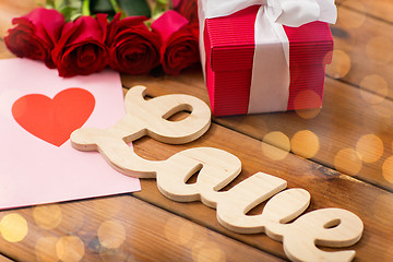 Image showing close up of gift box, red roses and greeting card