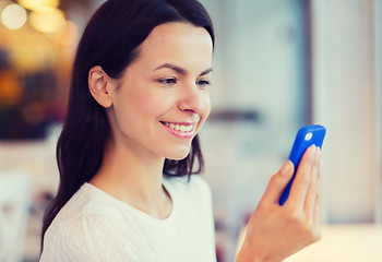 Image showing close up of smiling woman with smartphone at cafe