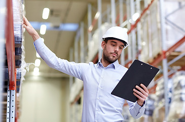 Image showing happy businessman with clipboard at warehouse