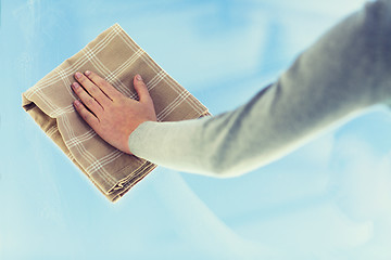 Image showing close up of woman hand cleaning window with cloth