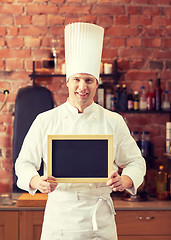 Image showing happy male chef with blank menu board in kitchen