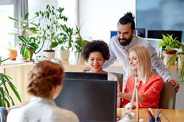 Image showing happy creative team with computer in office