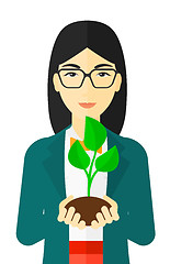 Image showing Woman holding plant.