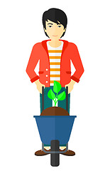 Image showing Man with plant and wheelbarrow.