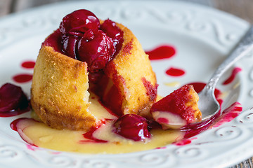 Image showing White chocolate fondant with cherry sauce.