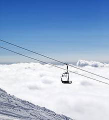 Image showing Ski slope, chair-lift and mountains under clouds