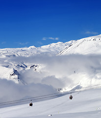 Image showing Off-piste snowy slope and cable car at sun day