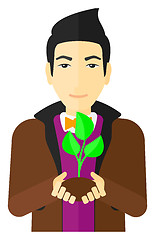 Image showing Man holding plant.