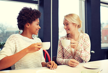 Image showing happy young women drinking tea or coffee at cafe