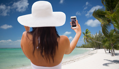 Image showing woman taking selfie with smartphone on beach