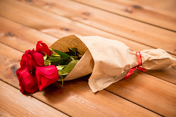 Image showing close up of red roses bunch wrapped into paper