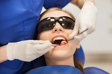 Image showing female dentist checking patient girl teeth