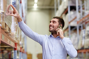 Image showing happy man calling on smartphone at warehouse