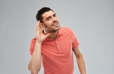 Image showing man having hearing problem listening to something