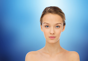 Image showing young woman face with bare shoulders over blue