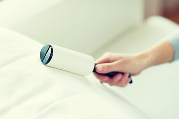 Image showing close up of woman hand with sticky roller cleaning