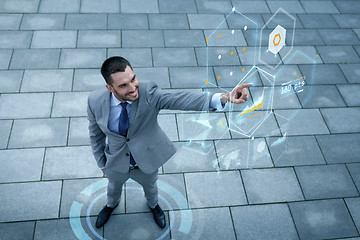 Image showing smiling businessman with virtual screens outdoors