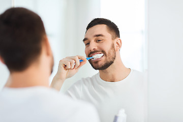 Image showing man with toothbrush cleaning teeth at bathroom