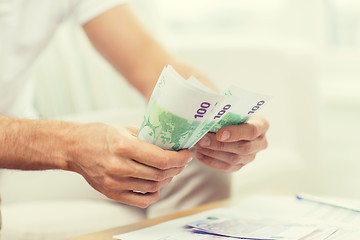 Image showing close up of man hands counting money at home