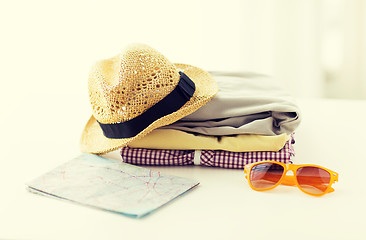 Image showing close up of summer clothes and travel map on table