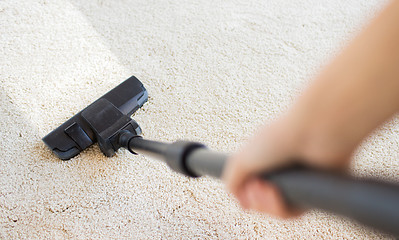 Image showing close up of hand with vacuum cleaner at home