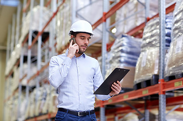 Image showing man with clipboard and smartphone at warehouse